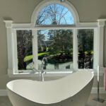 Bathtub by a bay window