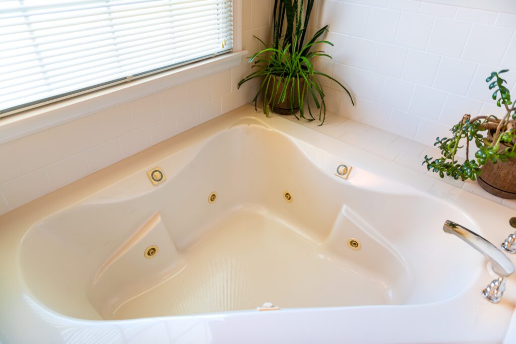 An overview of a large jetted tub near a window.